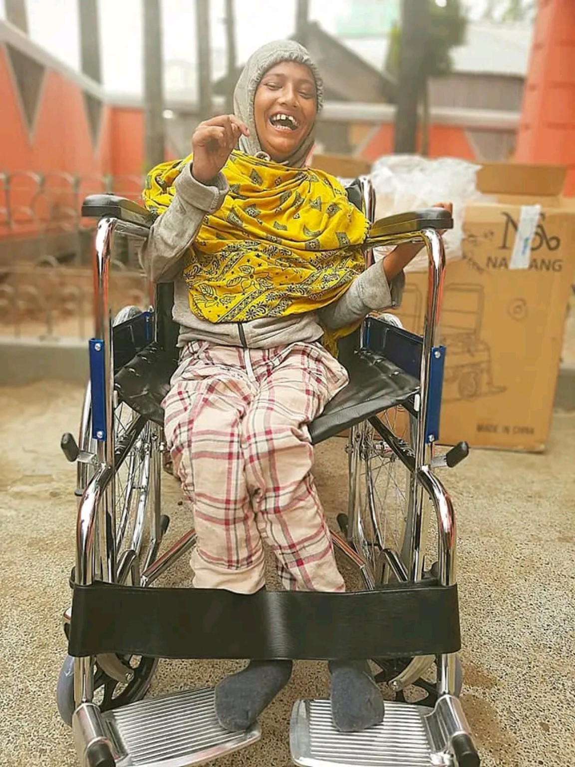 A smiling person seated in a wheelchair
